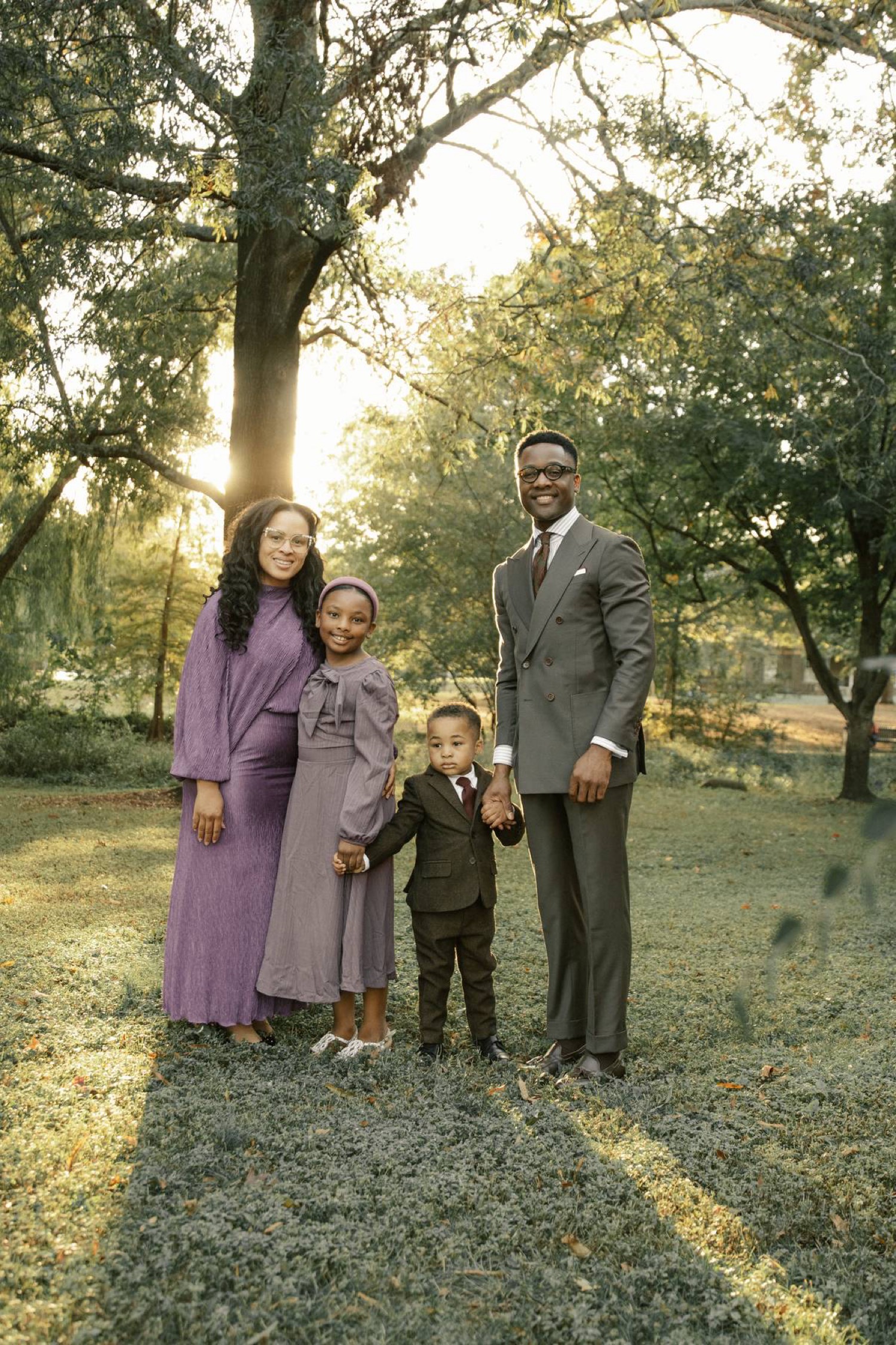 The Jones family standing together under the trees — Pastor JL Jones, First Lady Sheena Jones, Maevrie, and Greyson